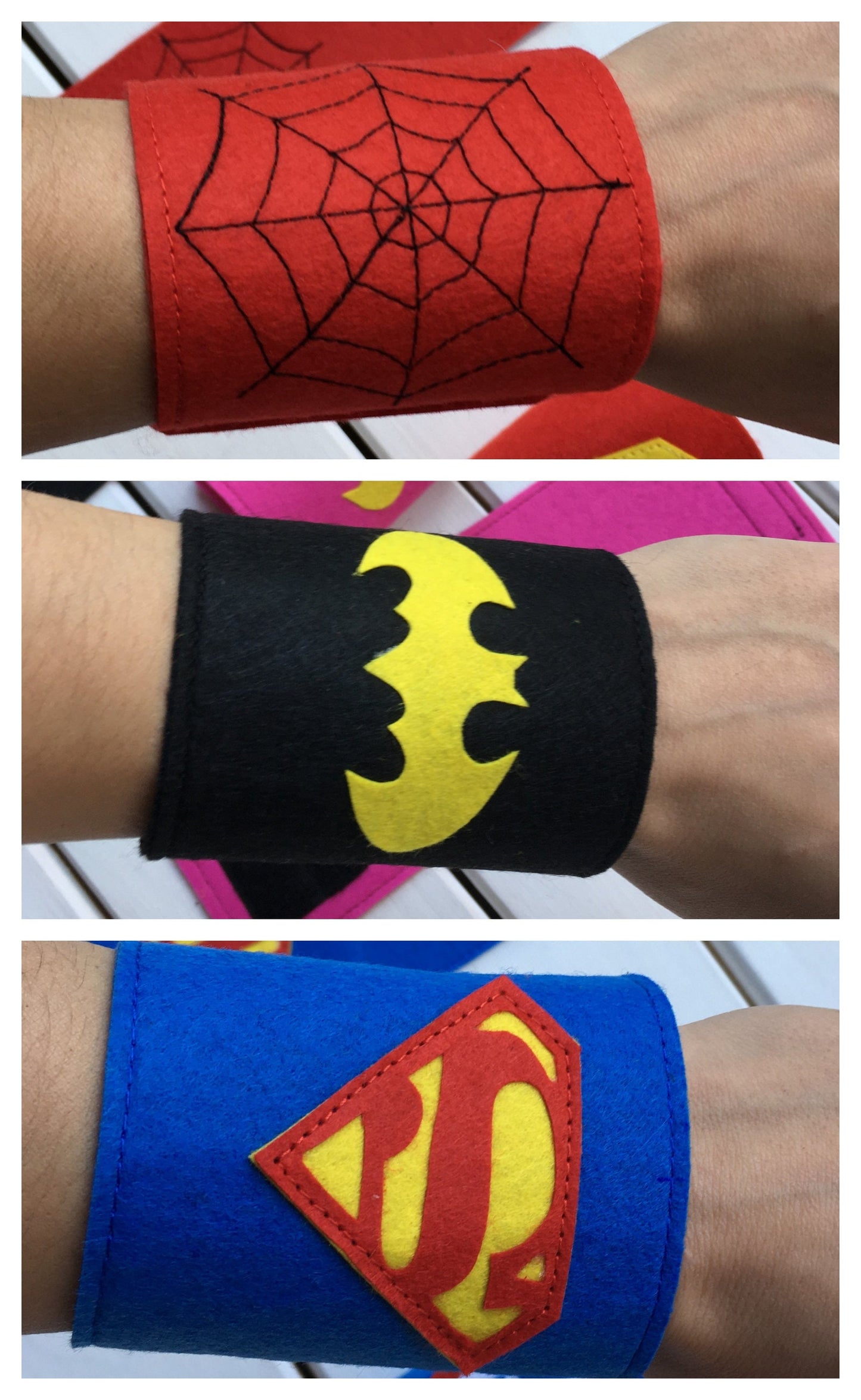 Superhero-themed wristbands with various symbols on a white wooden background