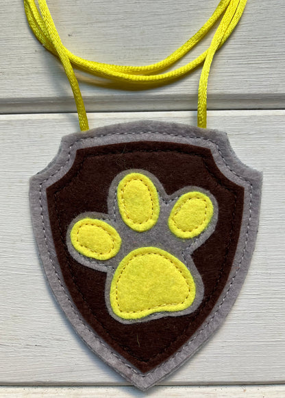 handmadeshield-shaped  felt badge with hanging string representing a paw patrol character
