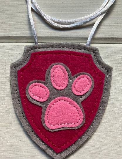 handmadeshield-shaped  felt badge with hanging string representing a paw patrol character