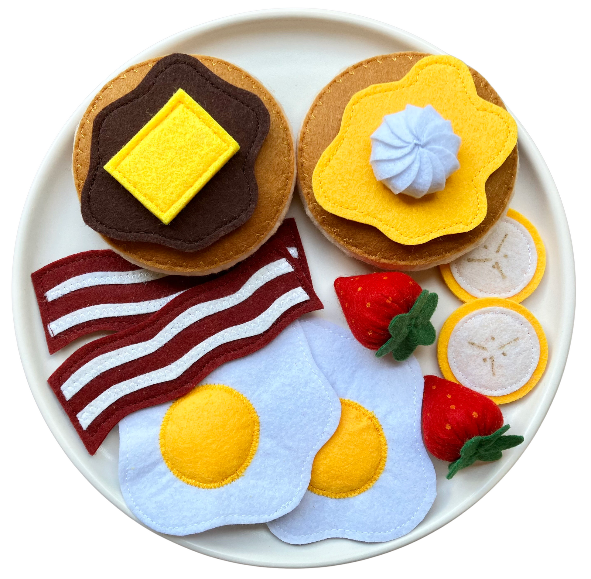 Handmade Felt food set resembling a breakfast plate with pancakes eggs, bacon, bananas, spreads and berries on a whitey background.