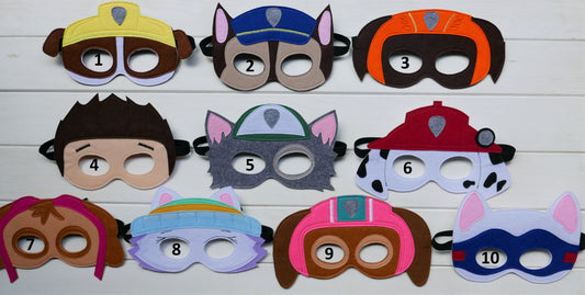 10 different paw patrol inspired handmade felt  masks, each representing a different character presented on a wooden surface