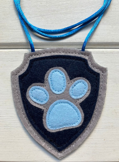 handmadeshield-shaped  felt badge with hanging string representing a paw patrol character
