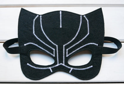 Handmade felt Black Panther arm cuffs presented on a white wooden surface