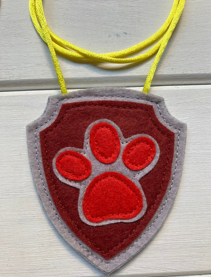 handmadeshield-shaped  felt badge with hanging string representing a paw patrol character